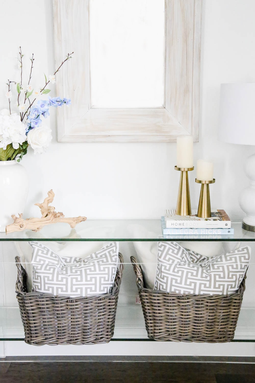 Baskets filled with pillows, spring flowers, gold candlesticks on a lucite table. #ABlissfulNest #springdecor #homedecor #decorideas