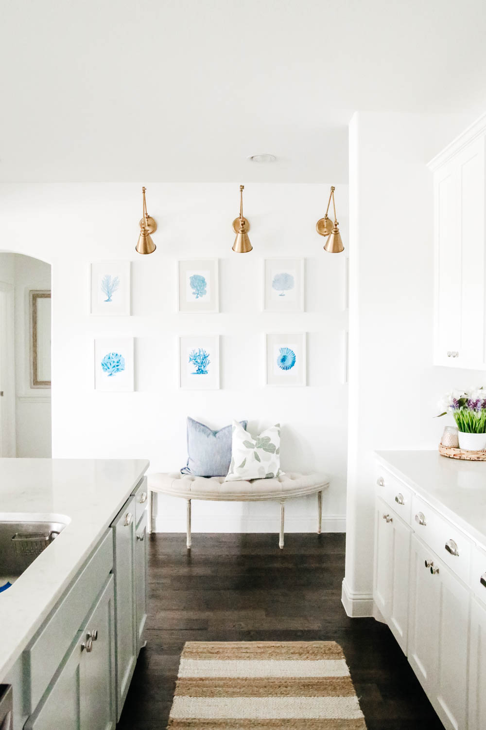 Gallery wall details in a white kitchen. Blue and white coastal art prints. #gallerywall #designtips #kitcheninspo #ABlissfulNest