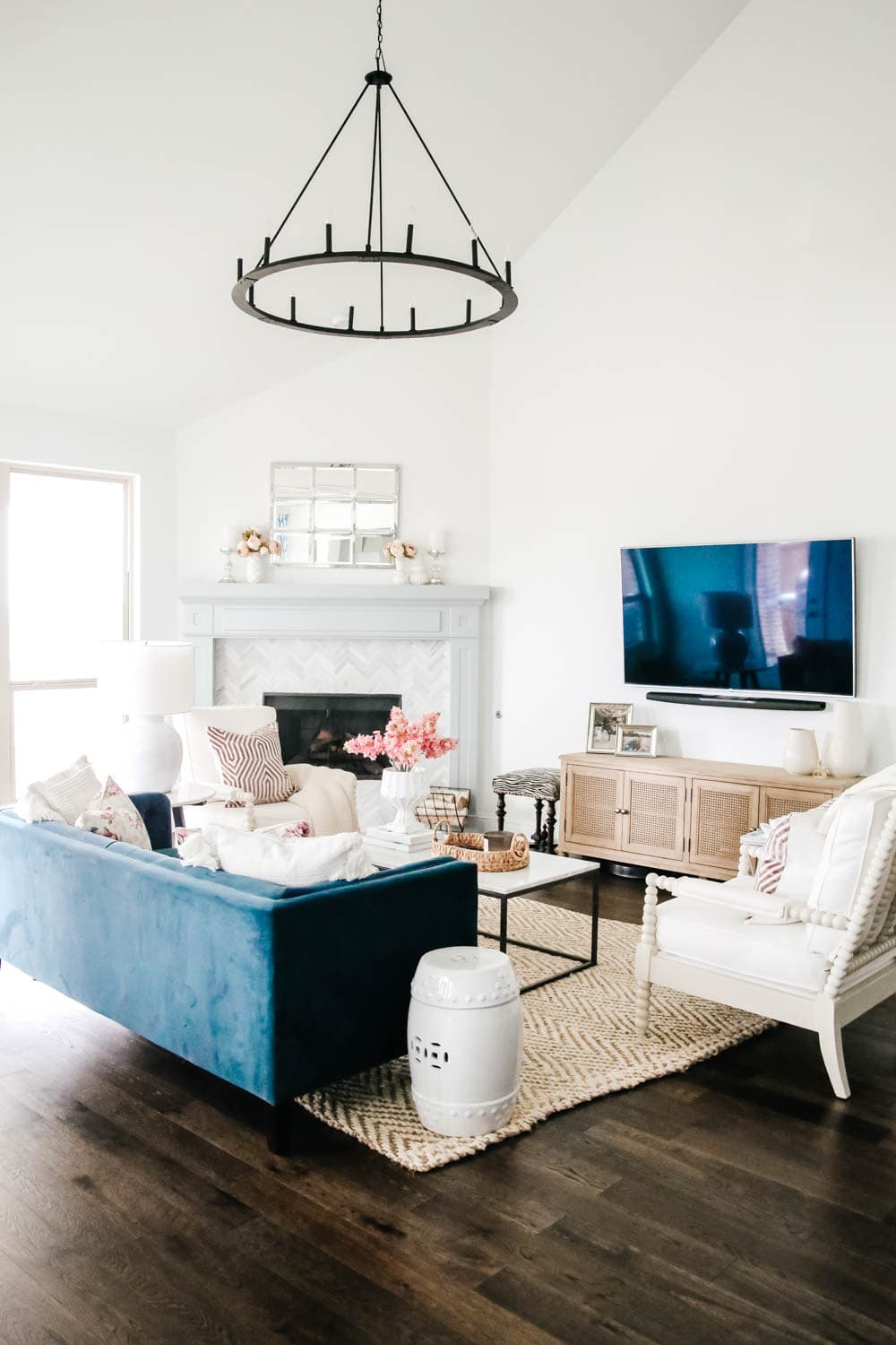 Living room with navy velvet sofa, bright white walls and soft lavender and pink touches. #springdecor #hometour #livingroom #ABlissfulNest