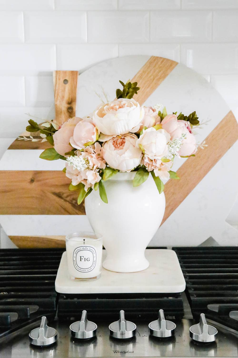White vase with pink peonies on kitchen range. #whitekitchen #kitcheninspo #kitchenideas #ABlissfulNest