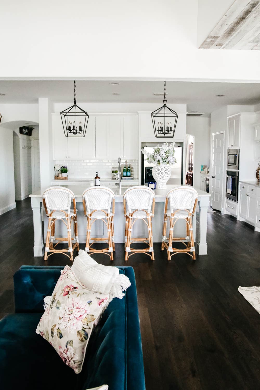 White kitchen with blue painted island. Rattan bistro chairs, black lanterns, carrara quartz counters. #ABlissfulNest #whitekitchen #springhometour