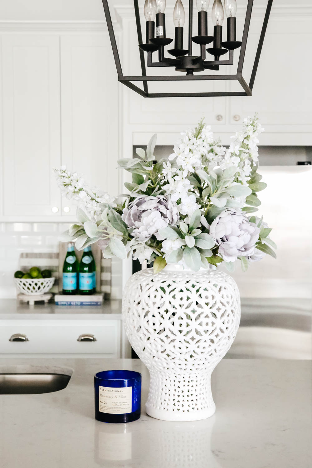 White lattice vase with flowers on white counter top. #whitekitchen #kitchendecor #kitchenideas #ABlissfulNest