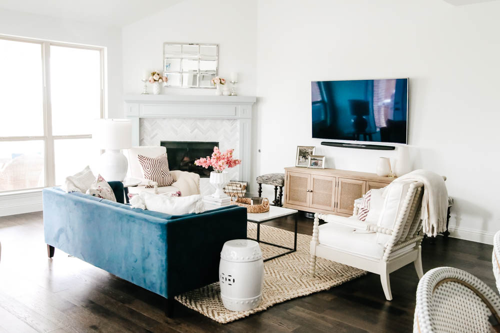 Living room with navy velvet sofa, bright white walls and soft lavender and pink touches. #springdecor #hometour #livingroom #ABlissfulNest