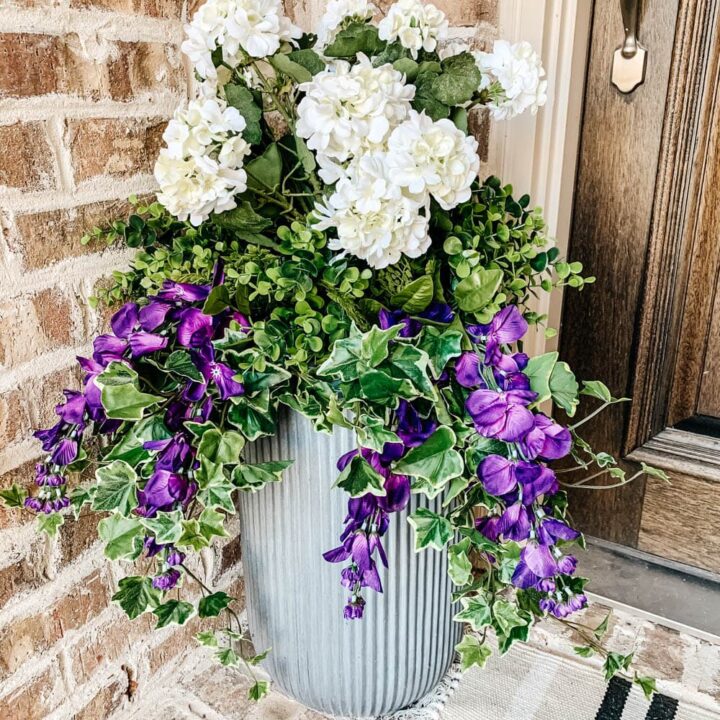 This planter is filled with UV protected artificial flowers and plants to create a stunning display. #ABlissfulNest #outdoorplanter #outdoordecorating