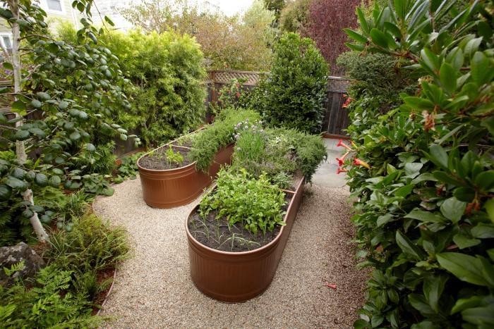 2 painted livestock water troughs transformed into raised garden beds