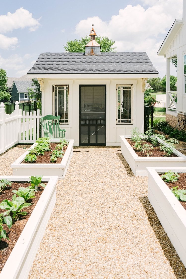 white painted raised garden beds with a gravel walkway