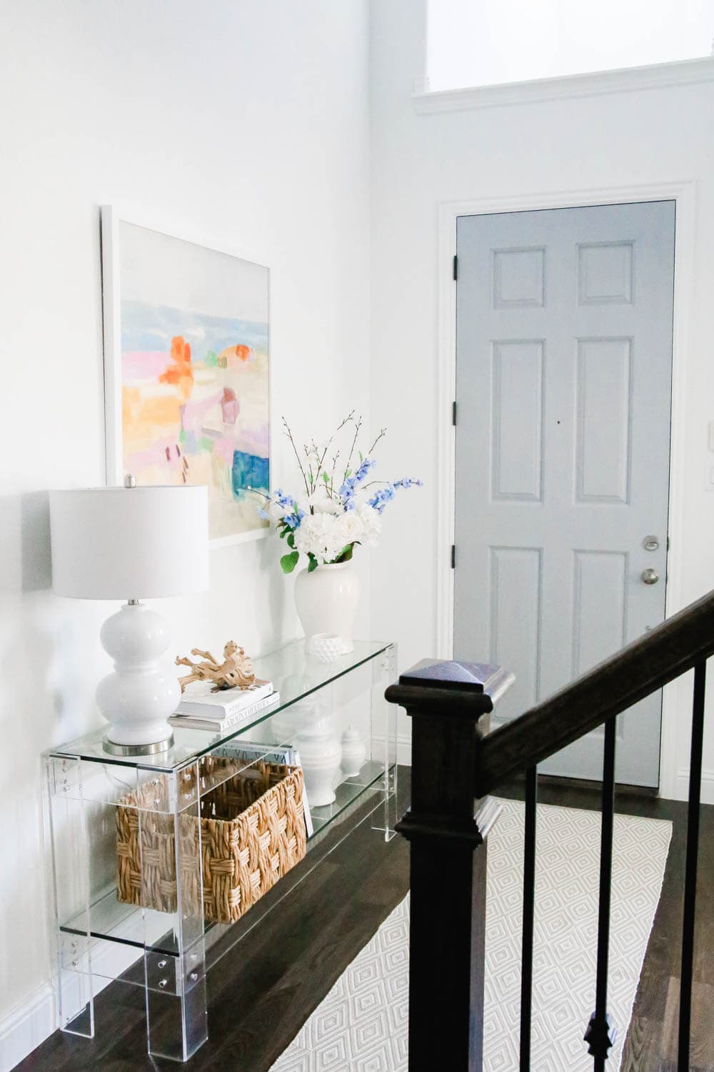 Blue front door in entryway with acrylic table, colorful modern art. #entryway #summerdecor #ABlissfulNest