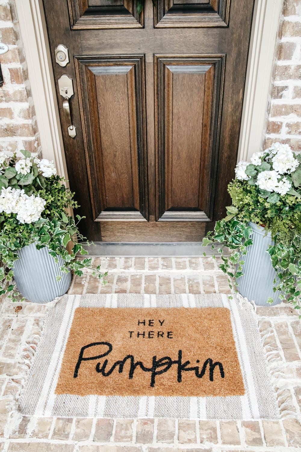 Layer your doormat with a patterned area rug for some contrast. #ABlissfulNest #fallporch