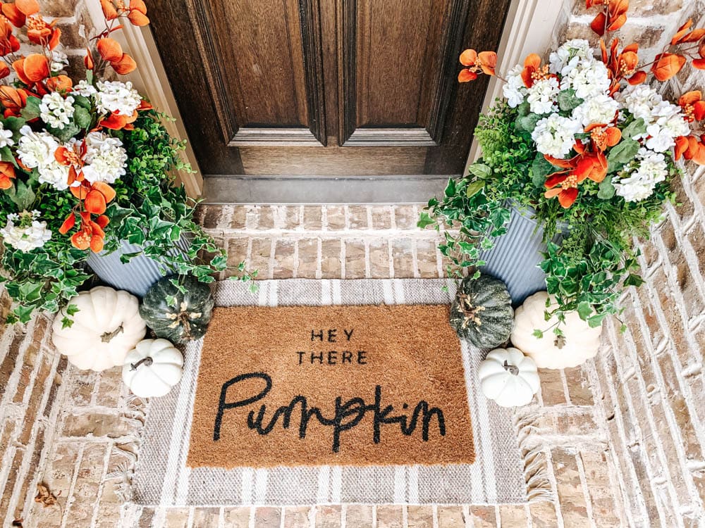 Layer your doormat with a patterned area rug for some contrast. #ABlissfulNest #fallporch