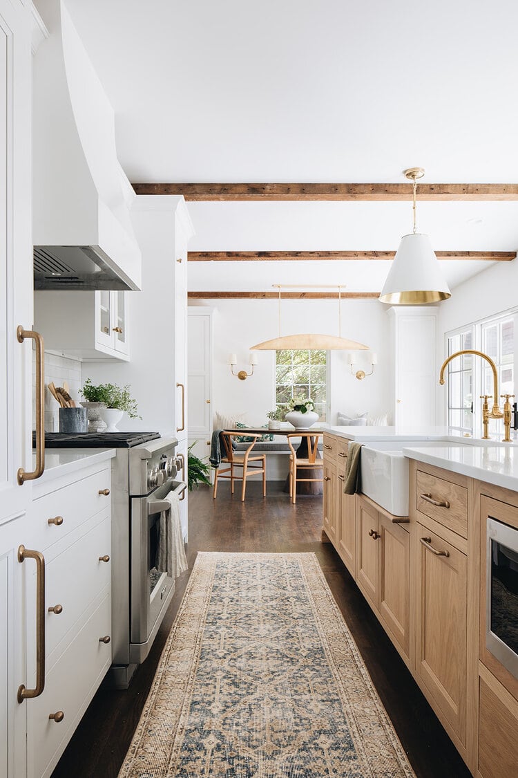 This gorgeous white and natural kitchen designed by Jean Stoffer Design has the most beautiful elements!