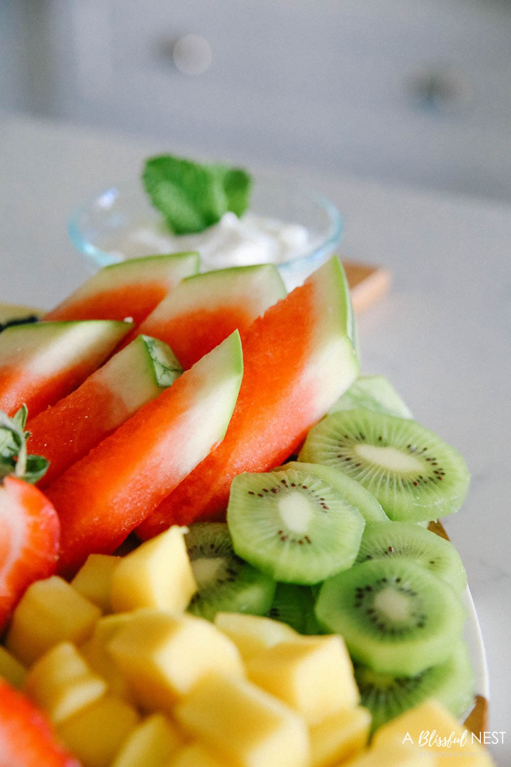 This beautiful fruit charcuterie board is so good to make on the weekends, for brunch, as an appetizer, and use all your favorite colorful fruits. #ABlissfulNest #charcuterieboard #fruitboard #fruitrecipe