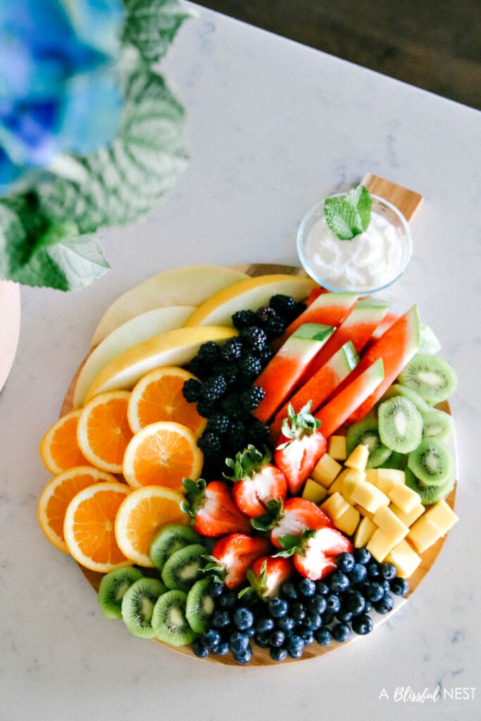 This beautiful fruit charcuterie board is so good to make on the weekends, for brunch, as an appetizer, and use all your favorite colorful fruits. #ABlissfulNest #charcuterieboard #fruitboard #fruitrecipe