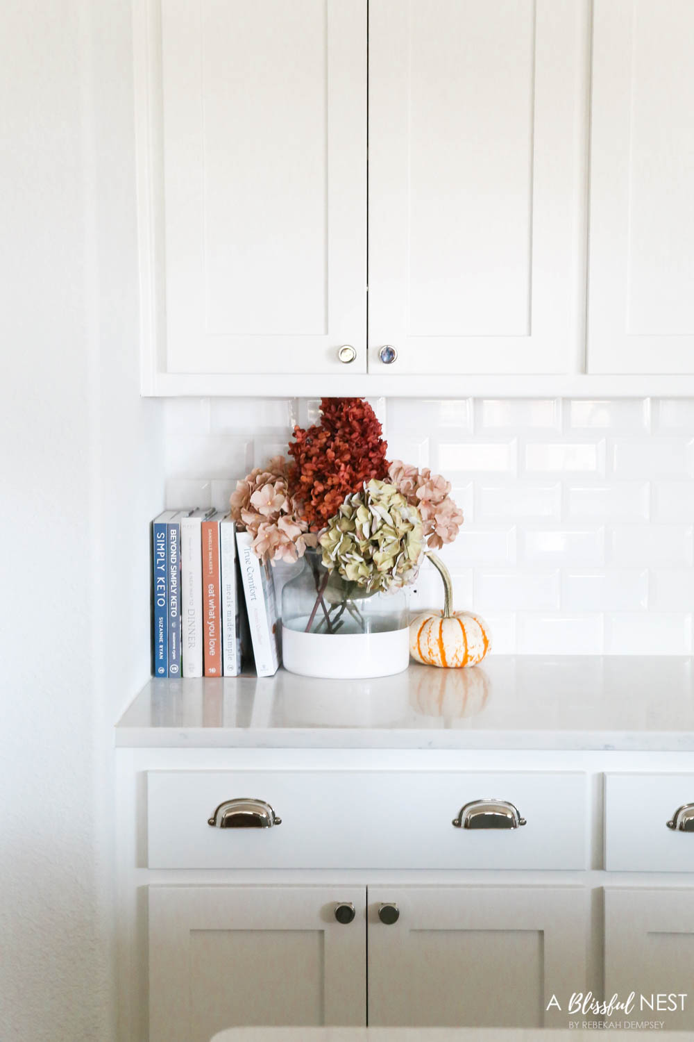 Beautiful fall decor details in this kitchen with burgundy eucalyptus leaves, delicious fall candles, Serena and Lily barstools. #ABlissfulNest #fallkitchen #falldecor #fallideas