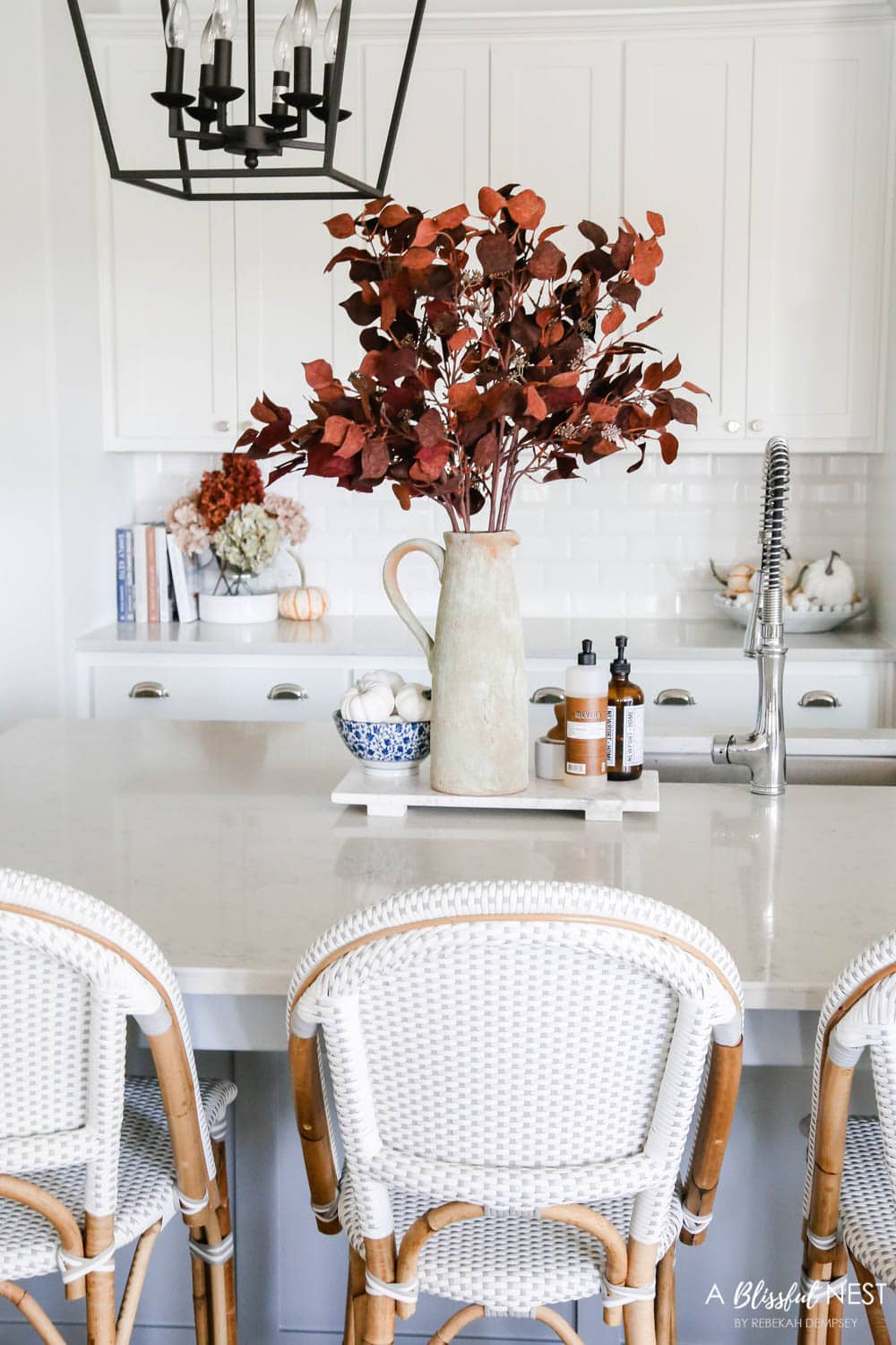 Beautiful fall decor details in this kitchen with burgundy eucalyptus leaves, delicious fall candles, Serena and Lily barstools. #ABlissfulNest #fallkitchen #falldecor #fallideas