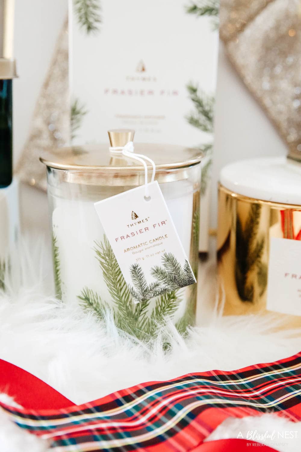 Candles and diffusers from Thymes under a Christmas tree.