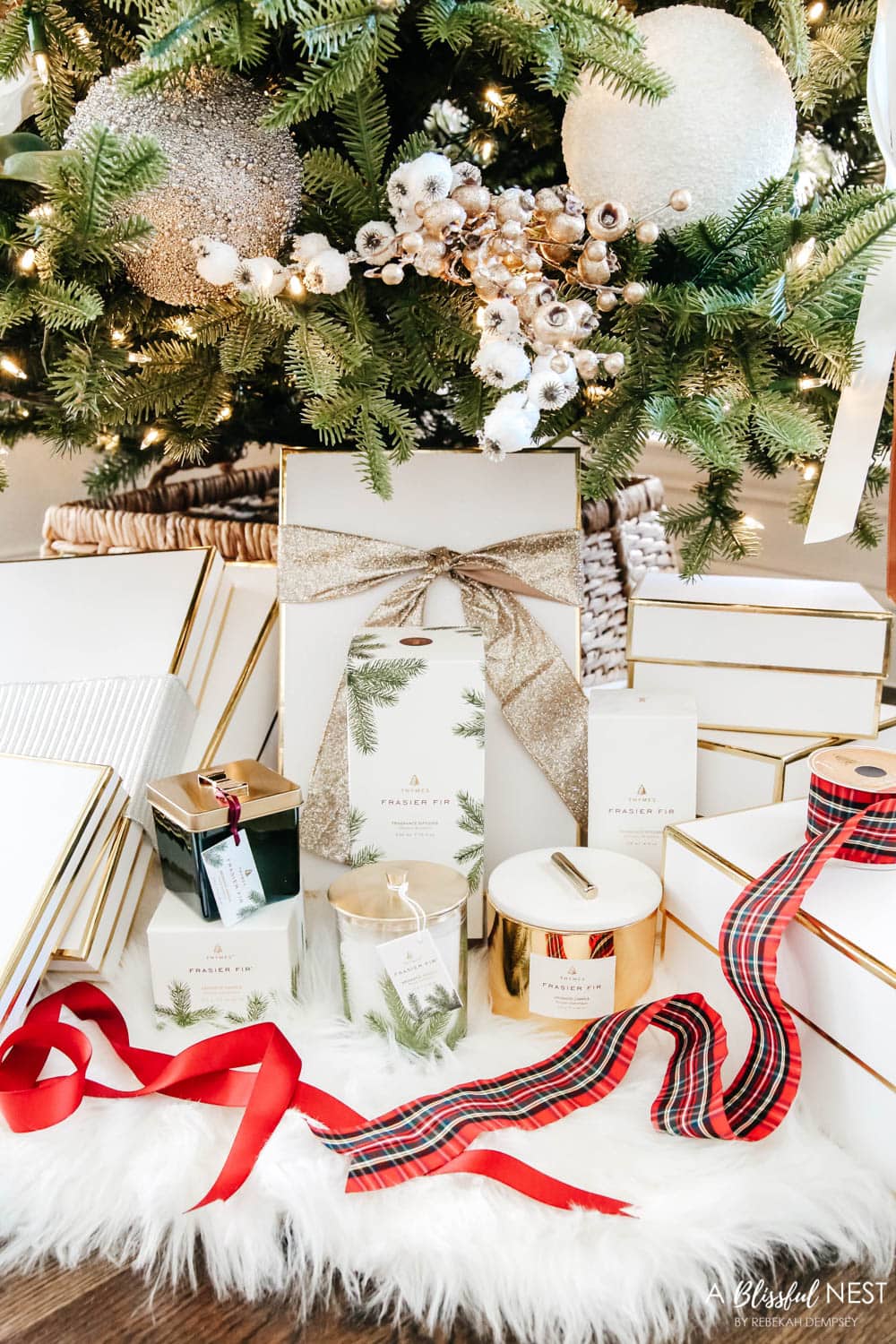 Candles and diffusers from Thymes under a Christmas tree.