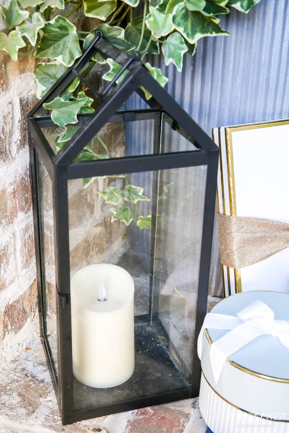 Black lantern with candle on a front porch.