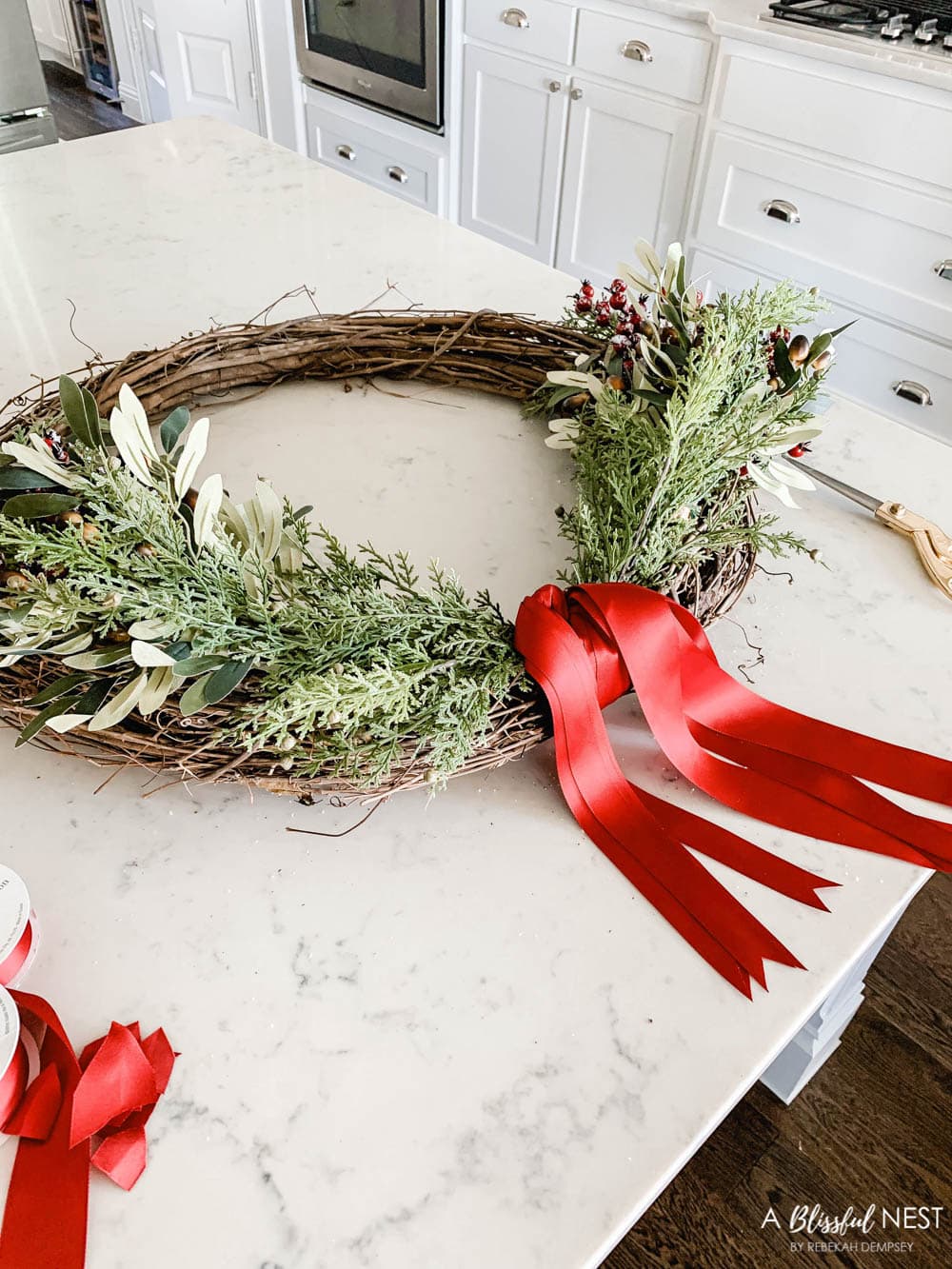 Step-by-step instructions to making this simple Christmas grapevine wreath for the holidays. #ABlissfulNest #HobbyLobby #sponsor #Christmaswreath