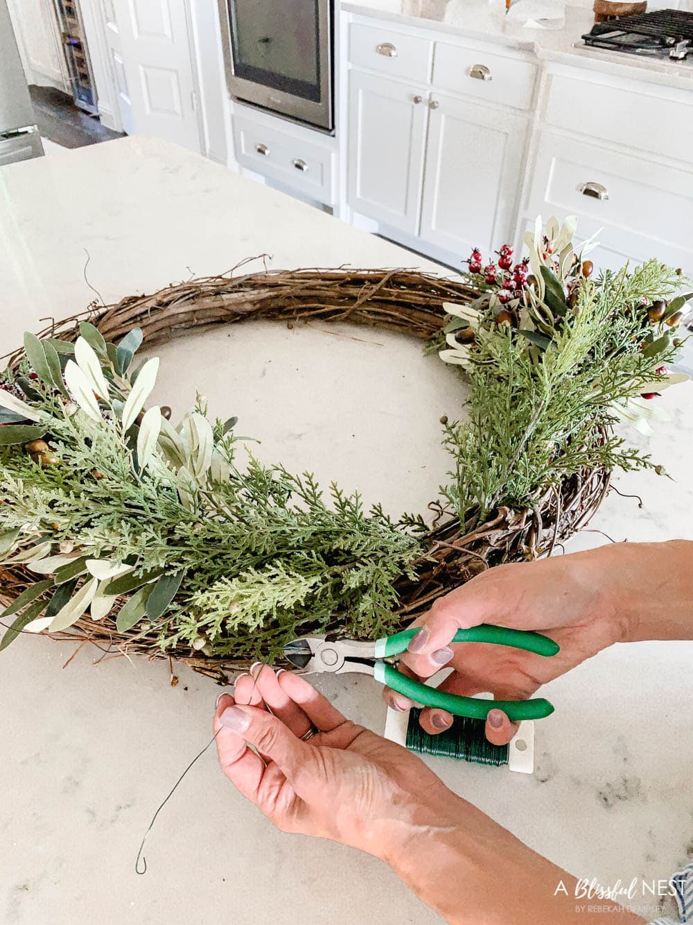 Step-by-step instructions to making this simple Christmas grapevine wreath for the holidays. #ABlissfulNest #HobbyLobby #sponsor #Christmaswreath