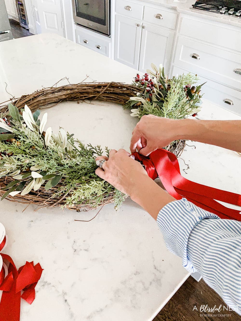 Step-by-step instructions to making this simple Christmas grapevine wreath for the holidays. #ABlissfulNest #HobbyLobby #sponsor #Christmaswreath