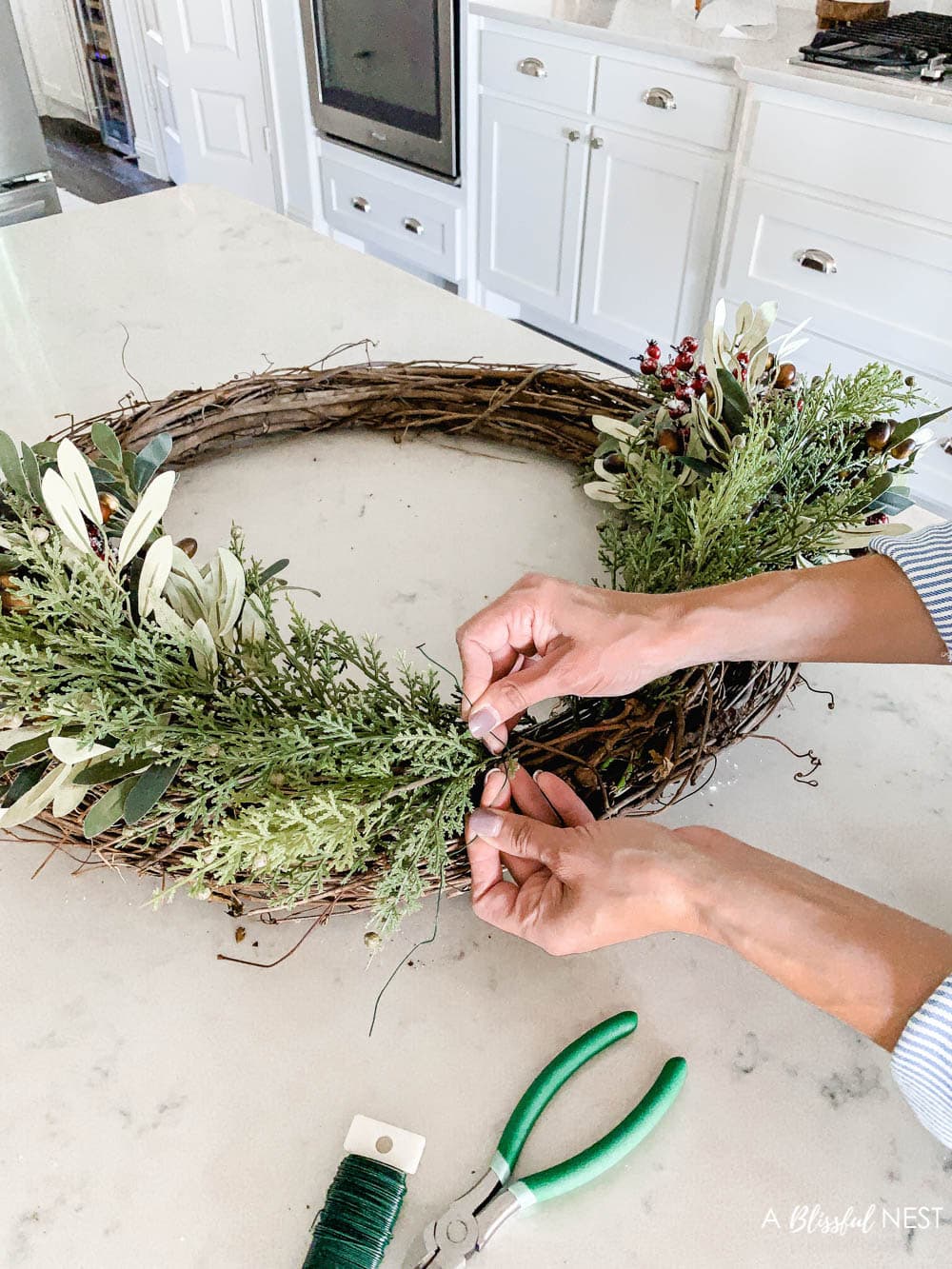 Step-by-step instructions to making this simple Christmas grapevine wreath for the holidays. #ABlissfulNest #HobbyLobby #sponsor #Christmaswreath