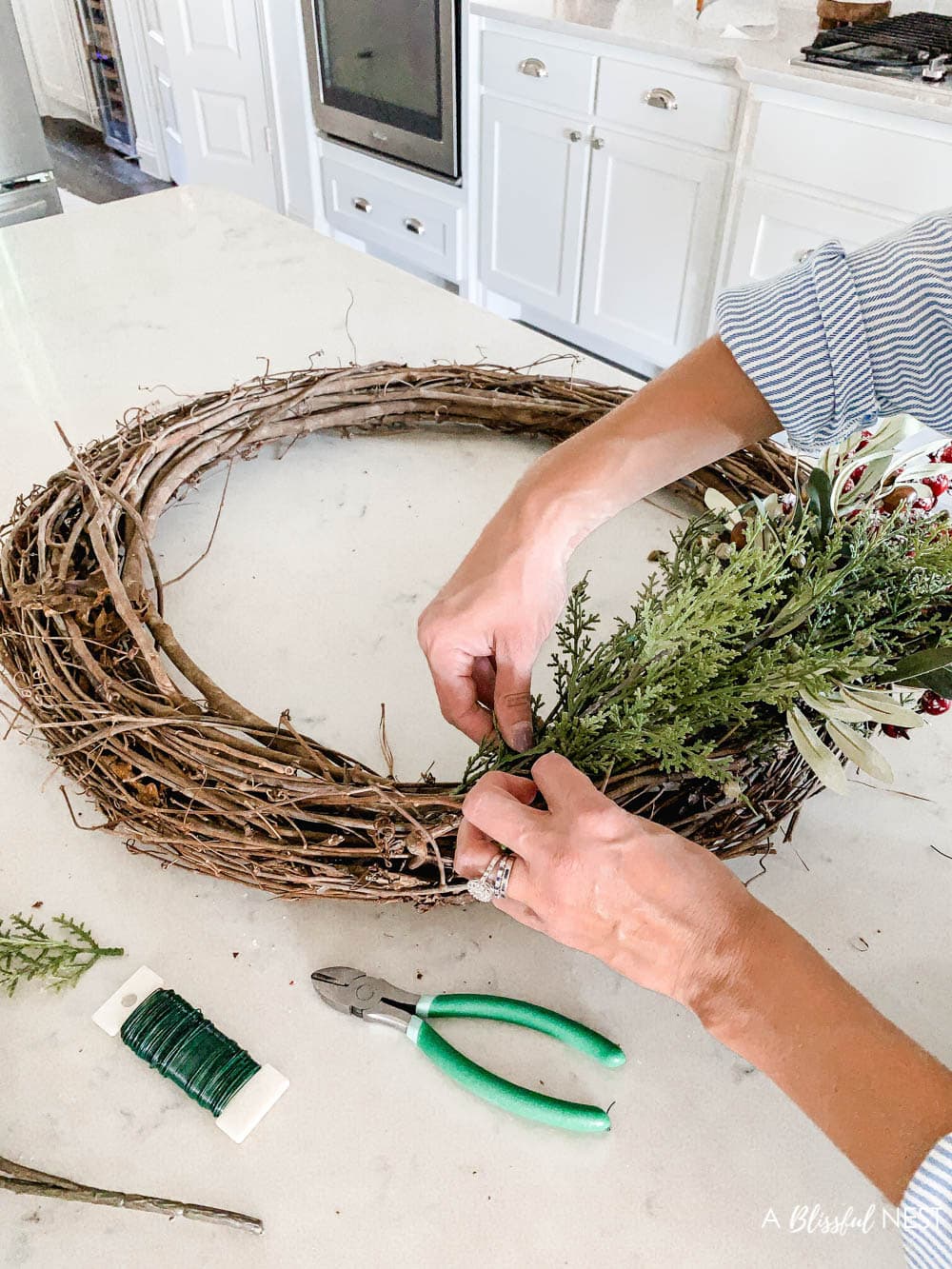 Step-by-step instructions to making this simple Christmas grapevine wreath for the holidays. #ABlissfulNest #HobbyLobby #sponsor #Christmaswreath