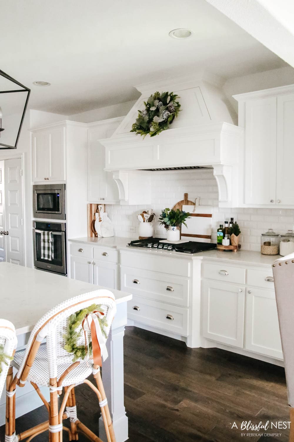 White kitchen with wreath on the hood and baking canisters on the counter