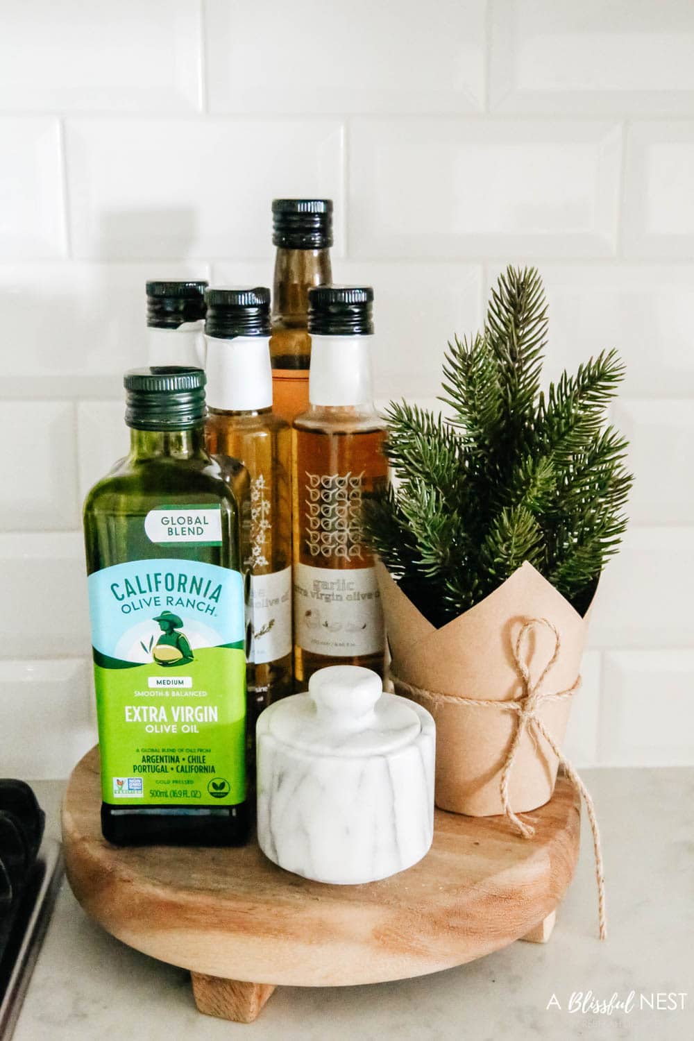 Cooking oils on a wood trivet next to a stove