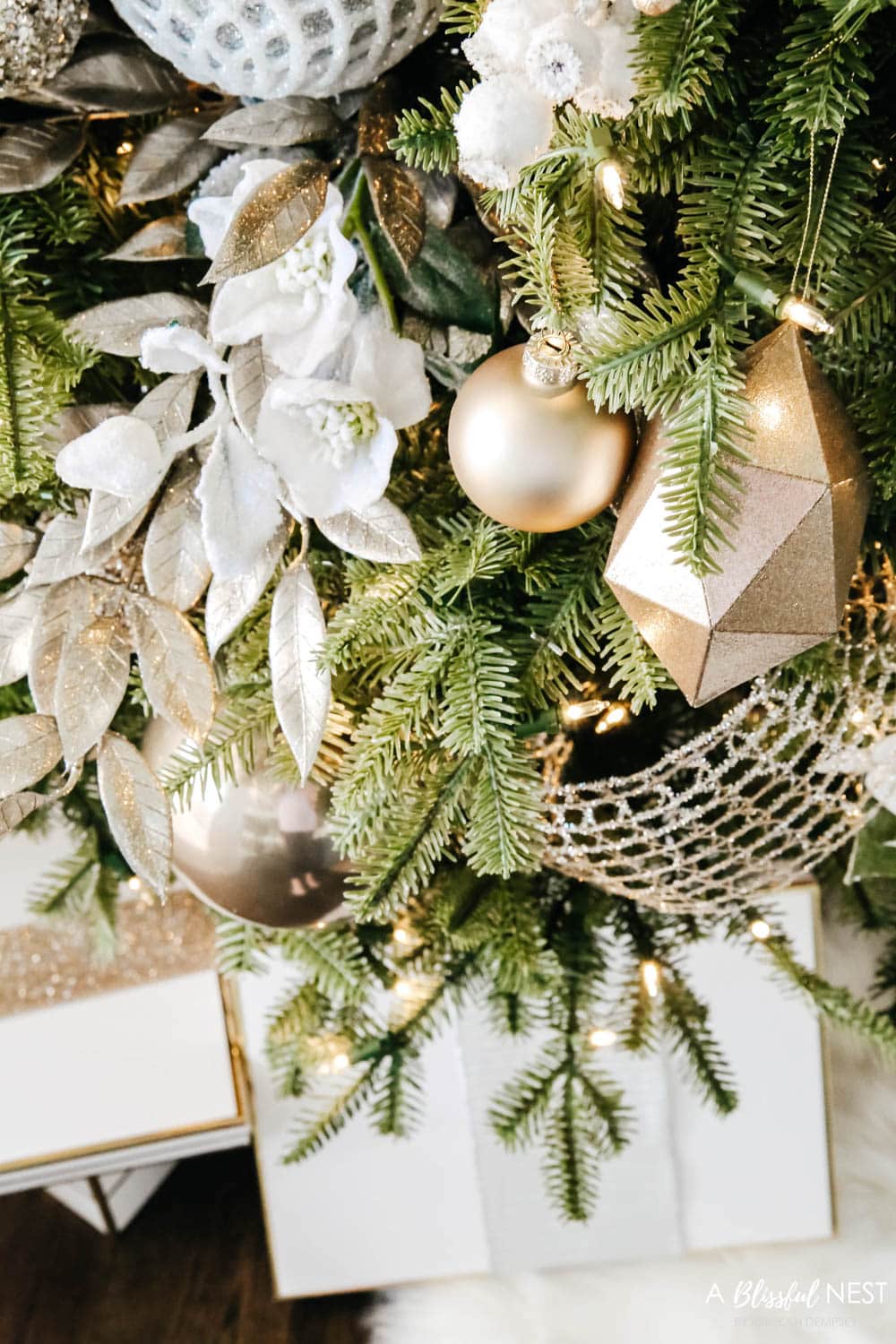 Gold and white floral picks in a Christmas tree with neutral colored ornaments