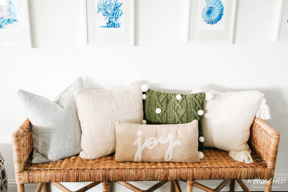 Neutral pillows on a rattan bench