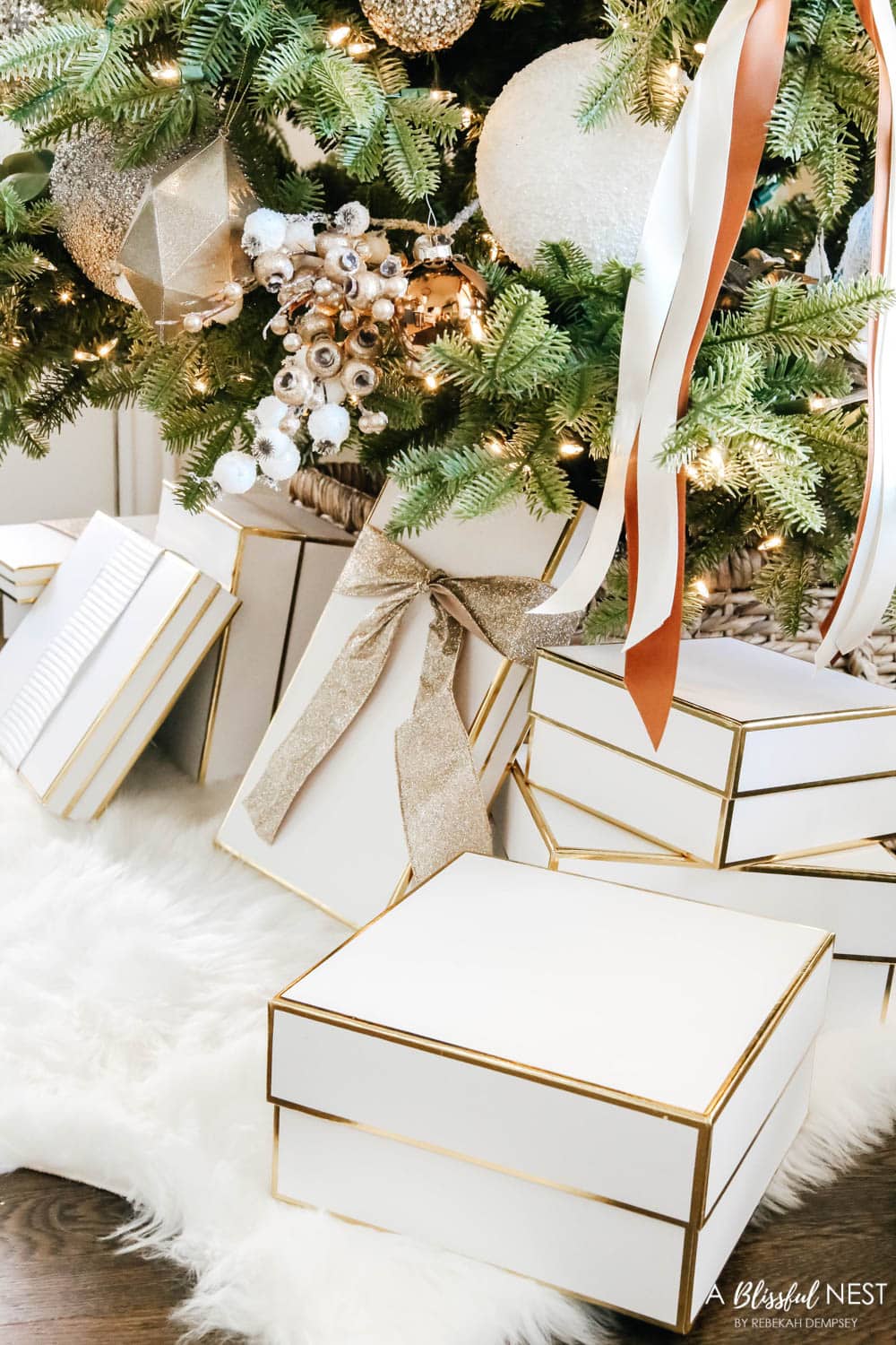 White and gold gift boxes under a Christmas tree.