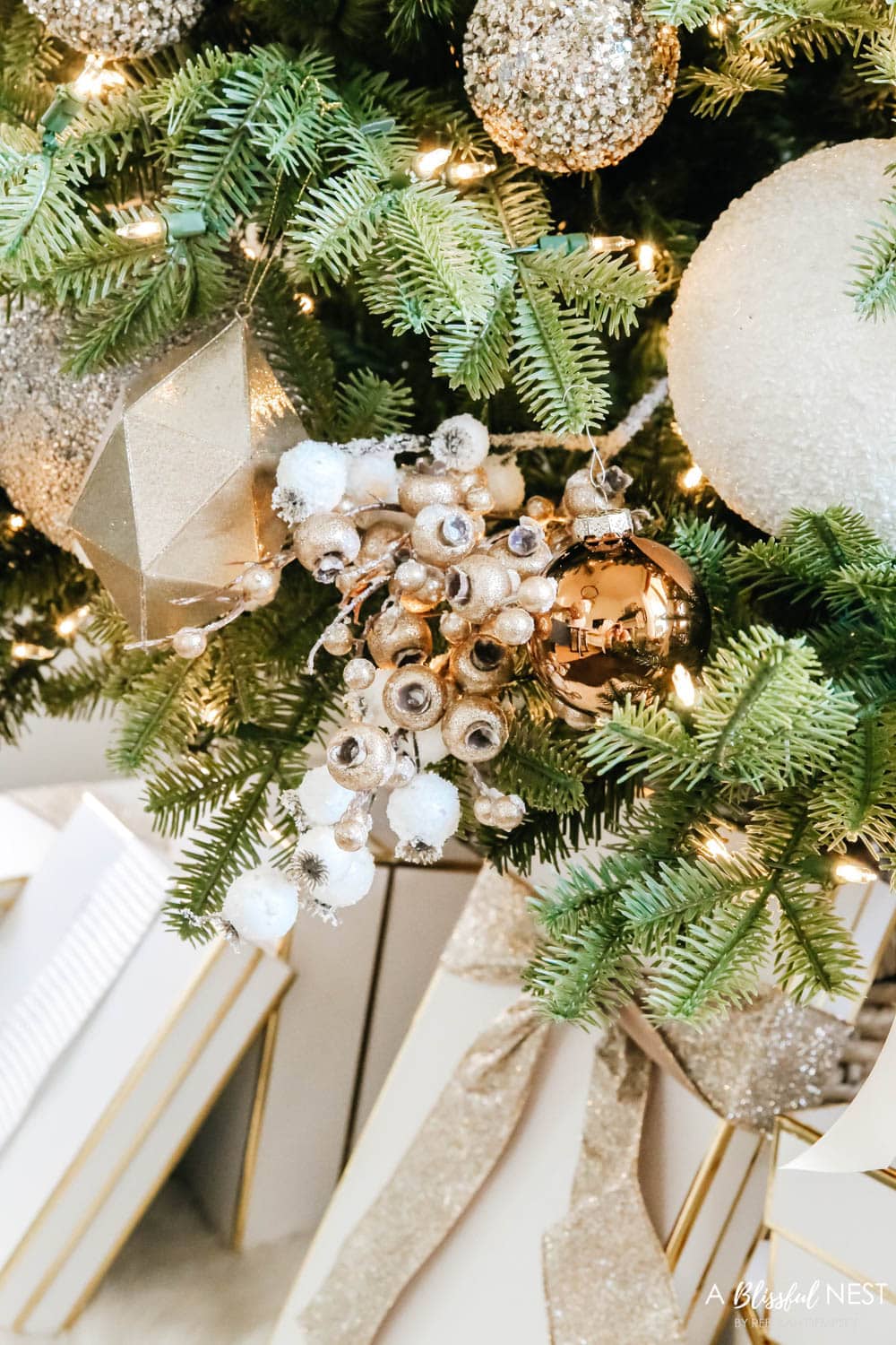 Gold and white floral picks in a Christmas tree with neutral colored ornaments
