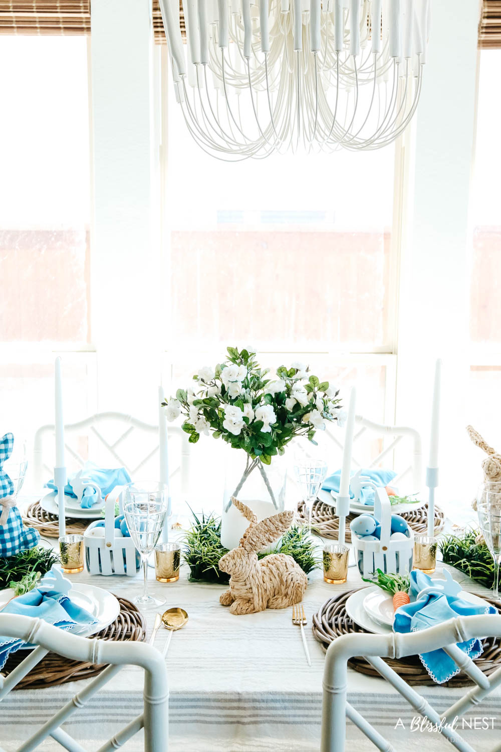 Overview of table setting with white flowers as the centerpiece and basketweave bunnies as accents