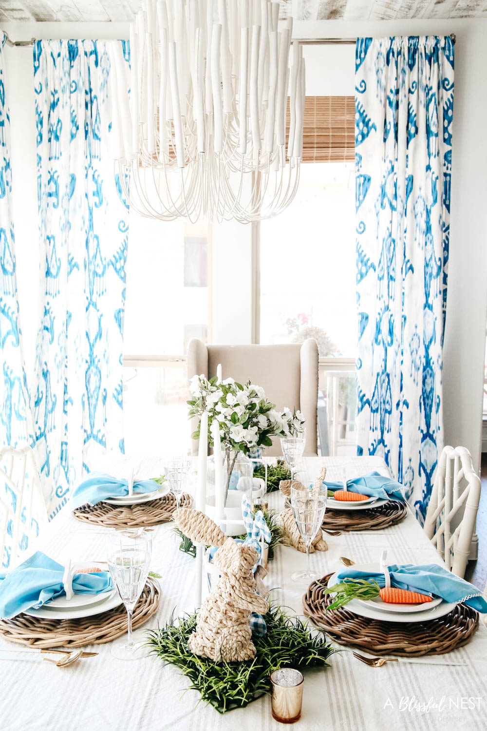 Overview of table setting with white flowers as the centerpiece and basketweave bunnies as accents