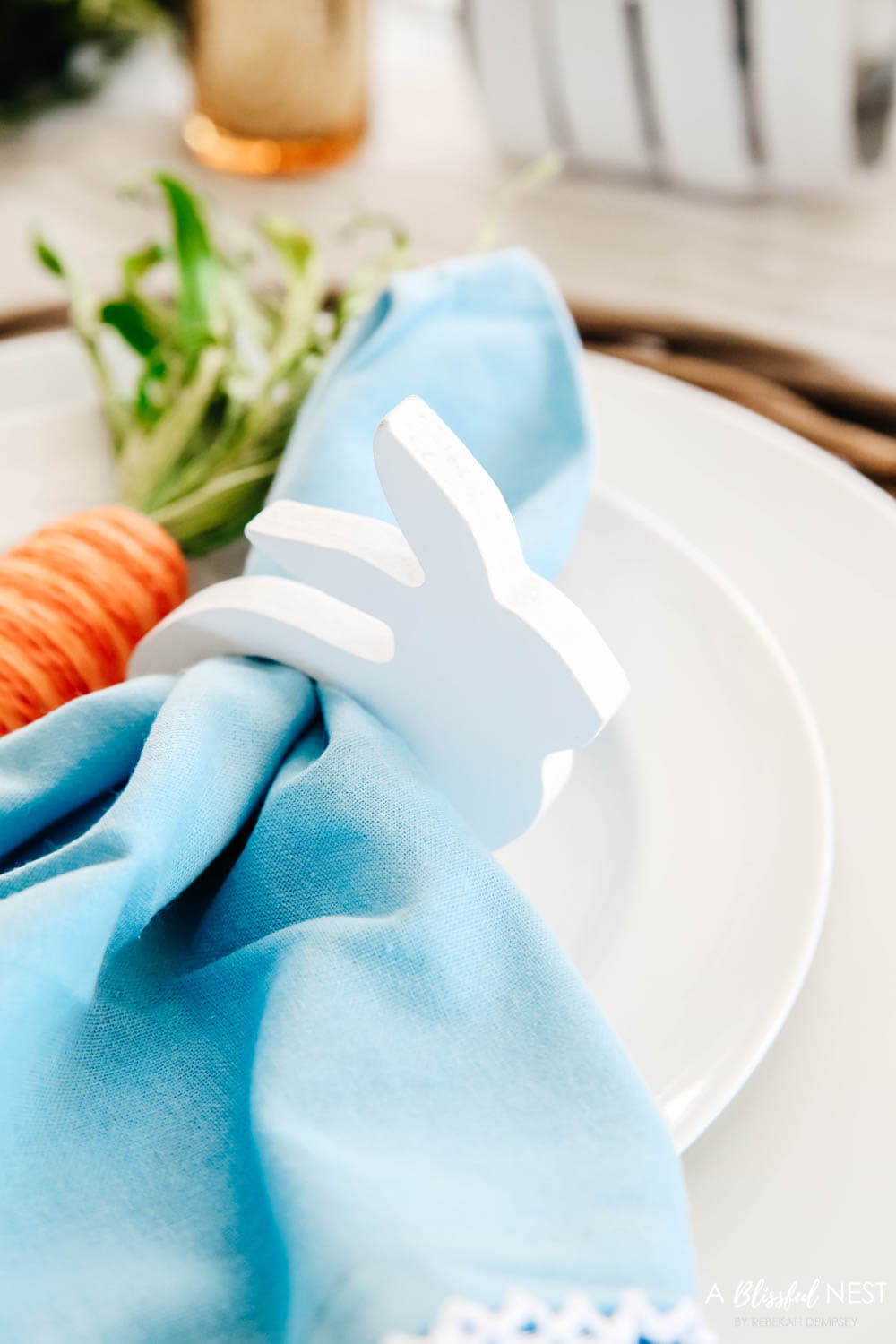 White wood bunny napkin holder with blue napkin tucked inside