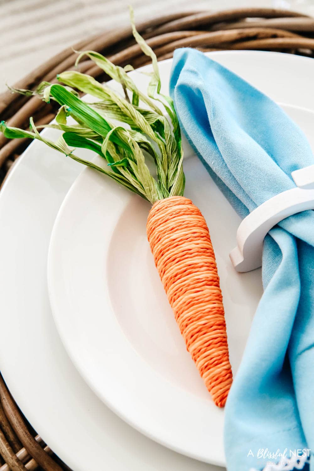 Jute two toned carrot resting on a white plate next to a blue napkin