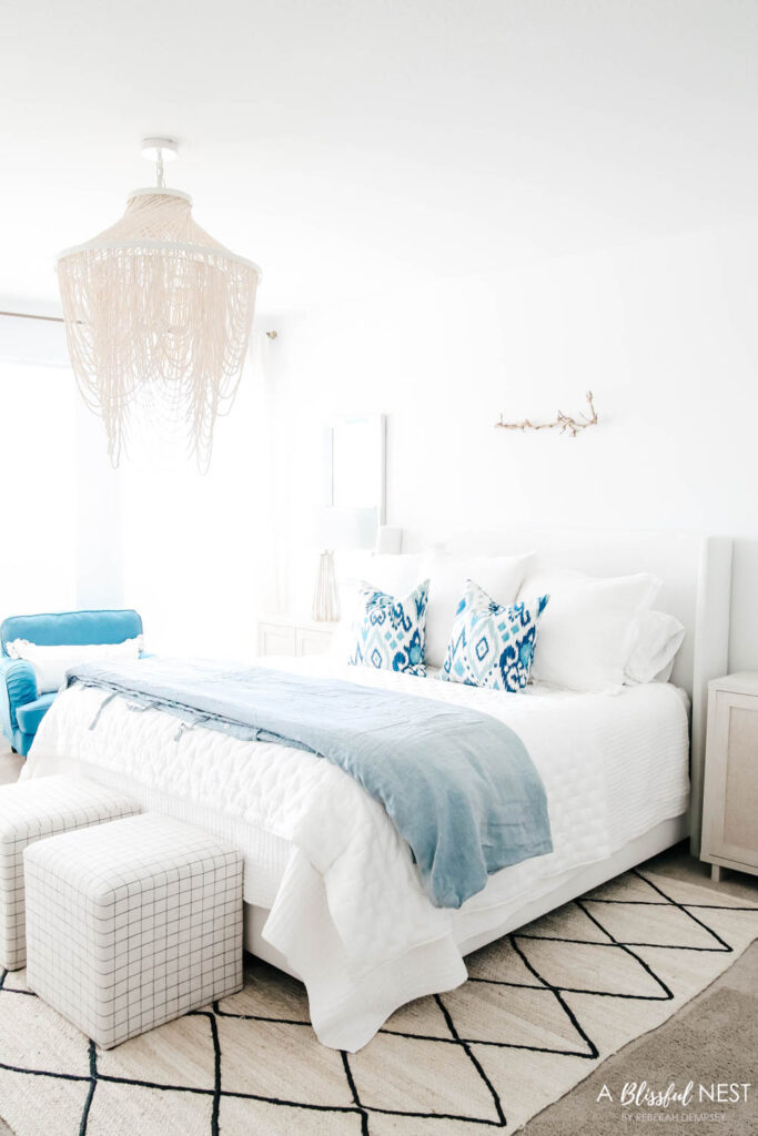 Master bedroom with blue and white details in bedding and furniture.