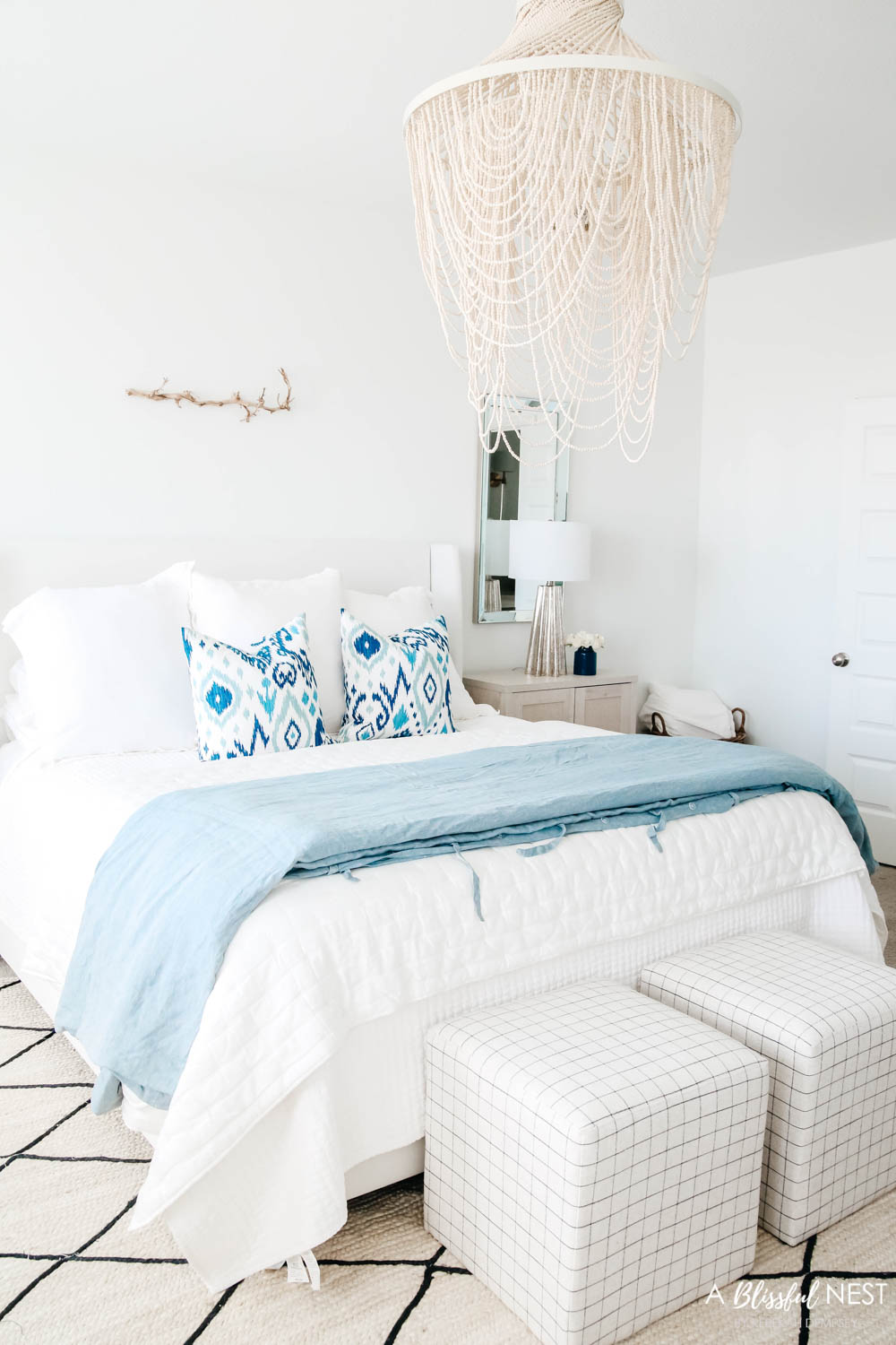 Master bedroom with blue and white details in bedding and furniture.
