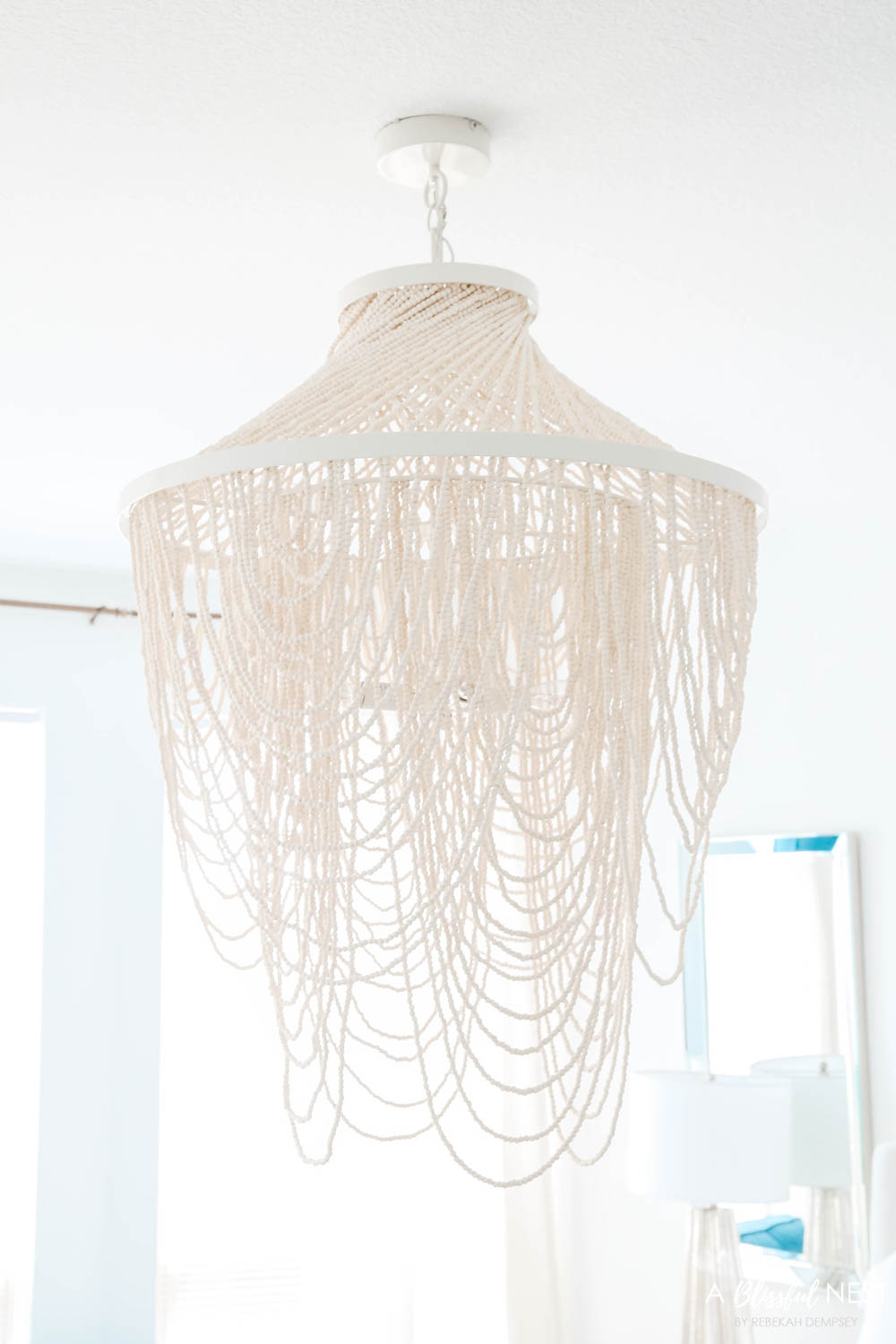 White beaded chandelier above the bed