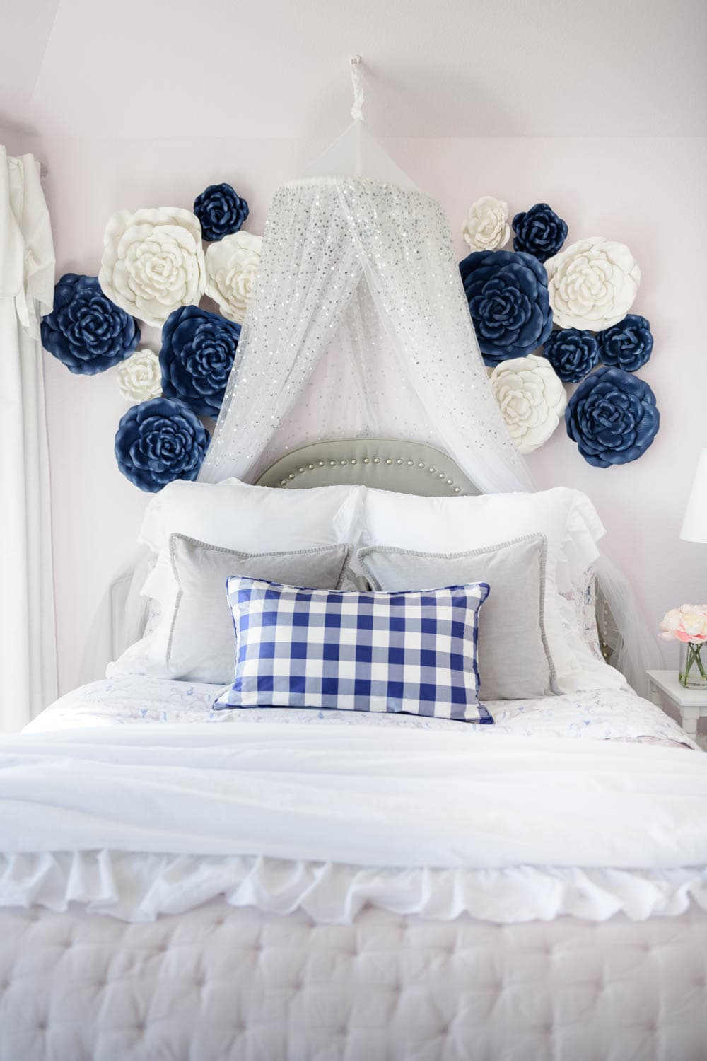 Lilac purple bedding with a navy and white check print pillow.