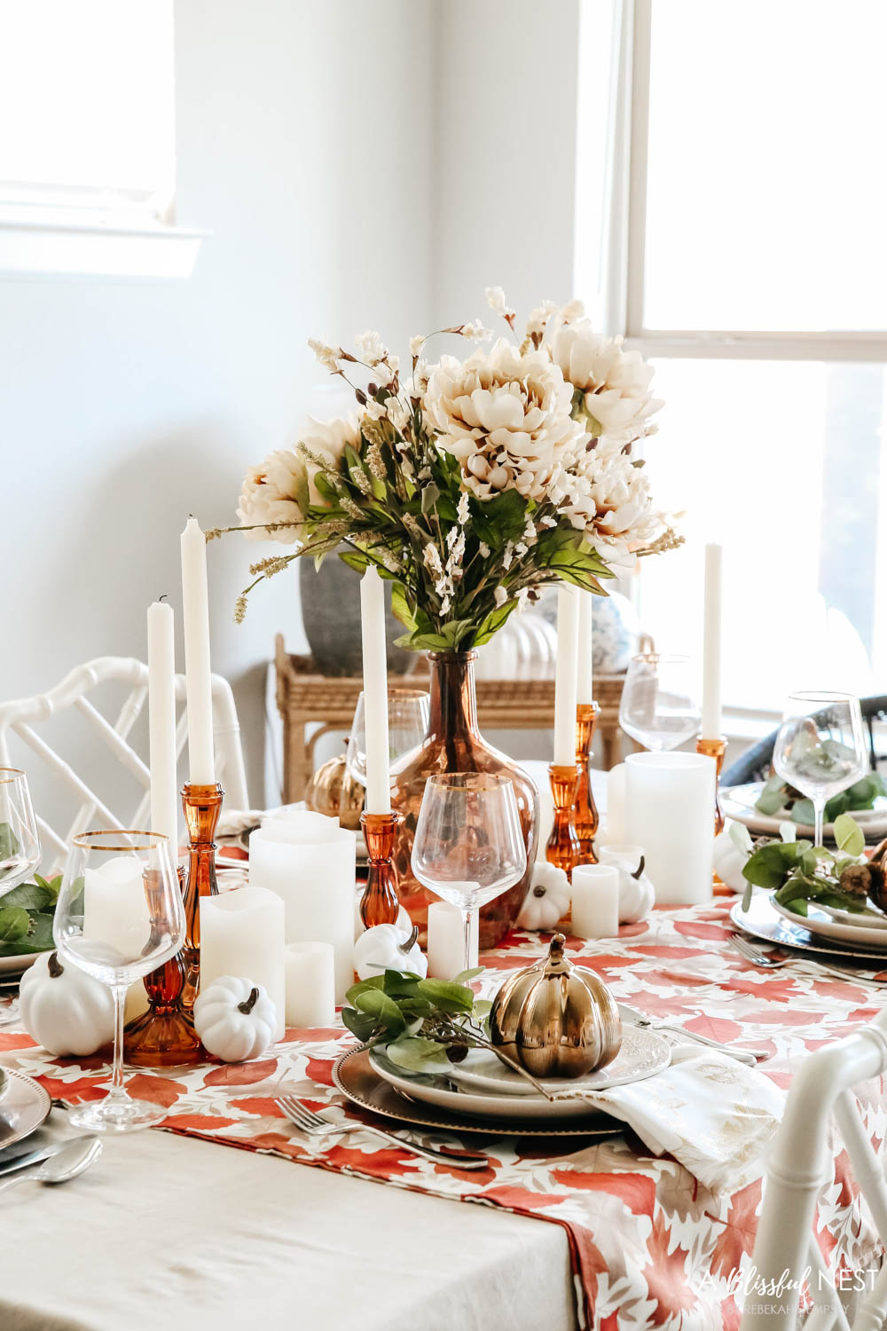 A fall table set with shades of oranges and taupe linens