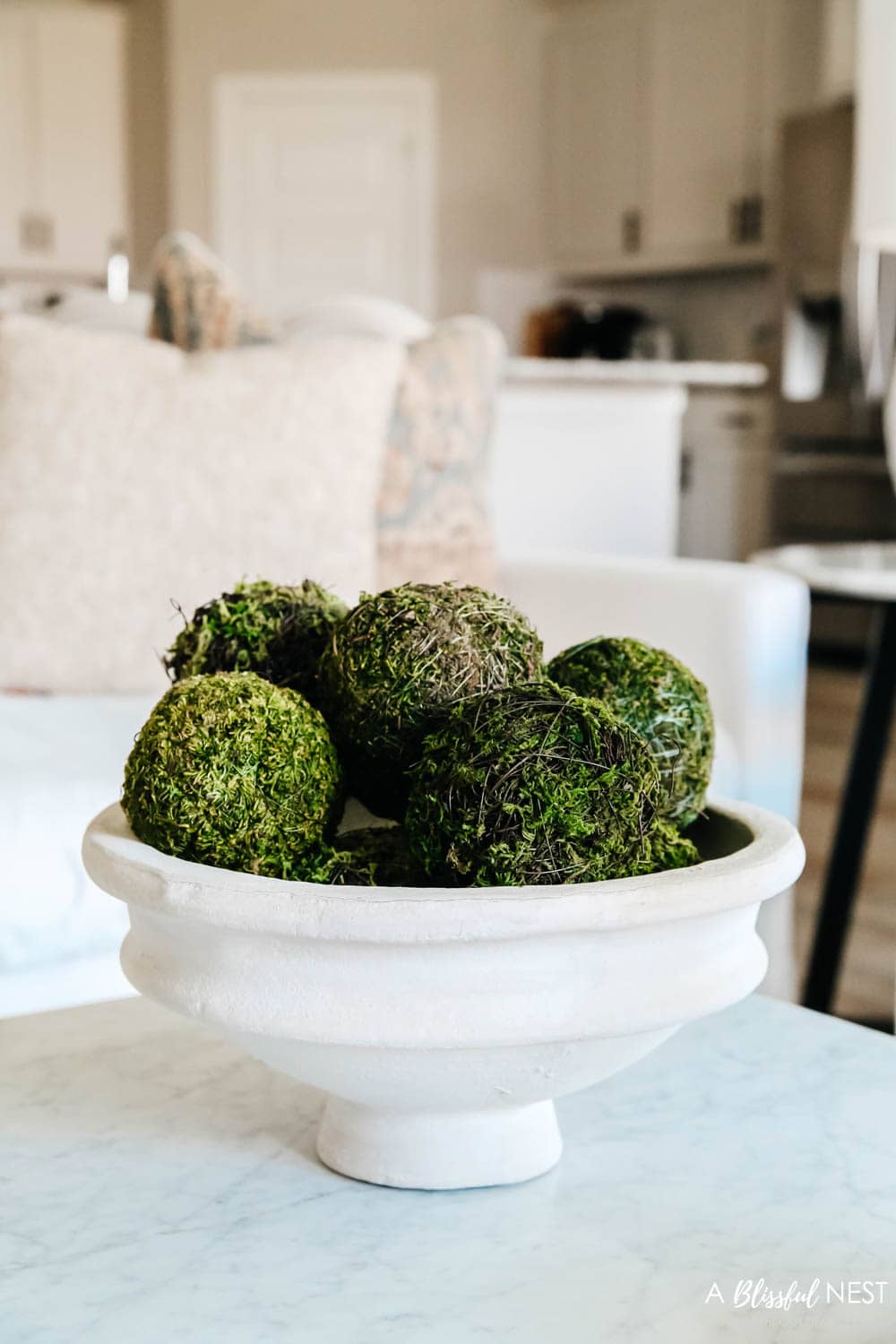 Papermache bowl with moss balls sitting on a coffee table
