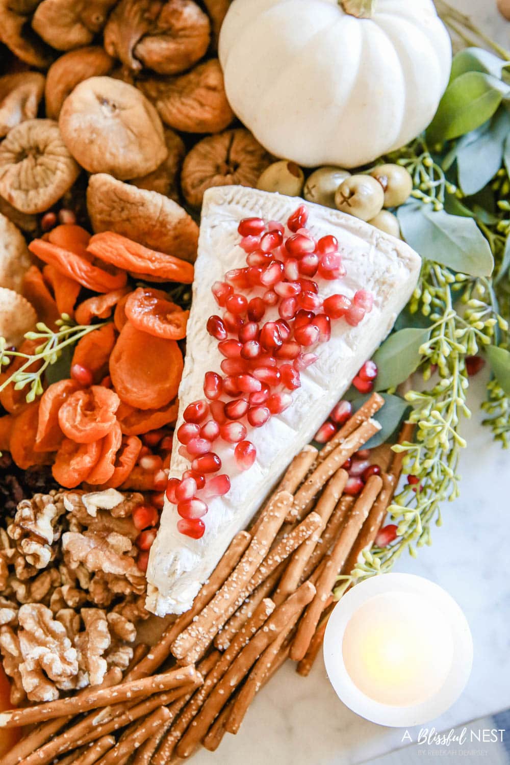 Brie cheese with pomegranate seeds sprinkled on top.