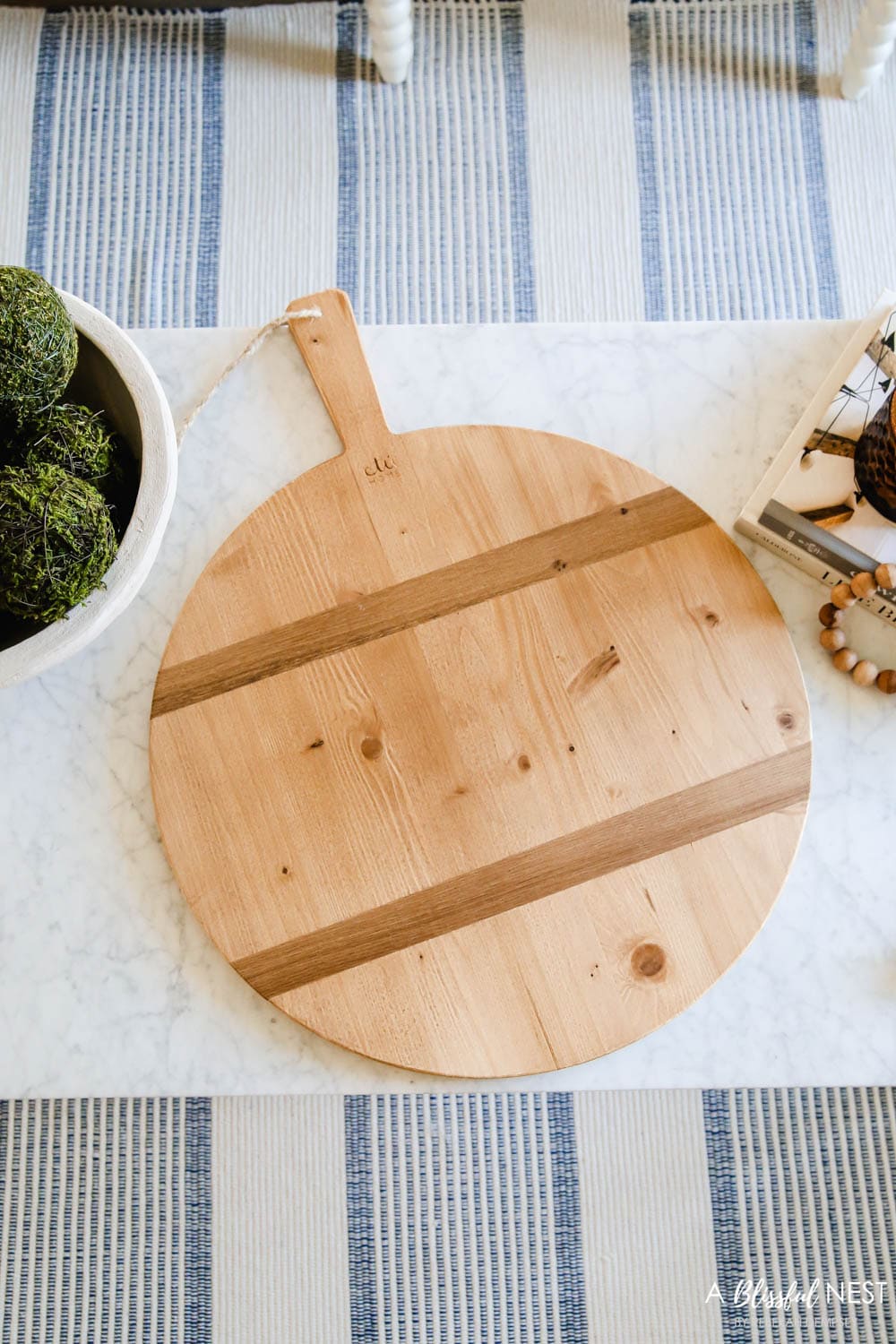 Round wood cutting board on a marble coffee table