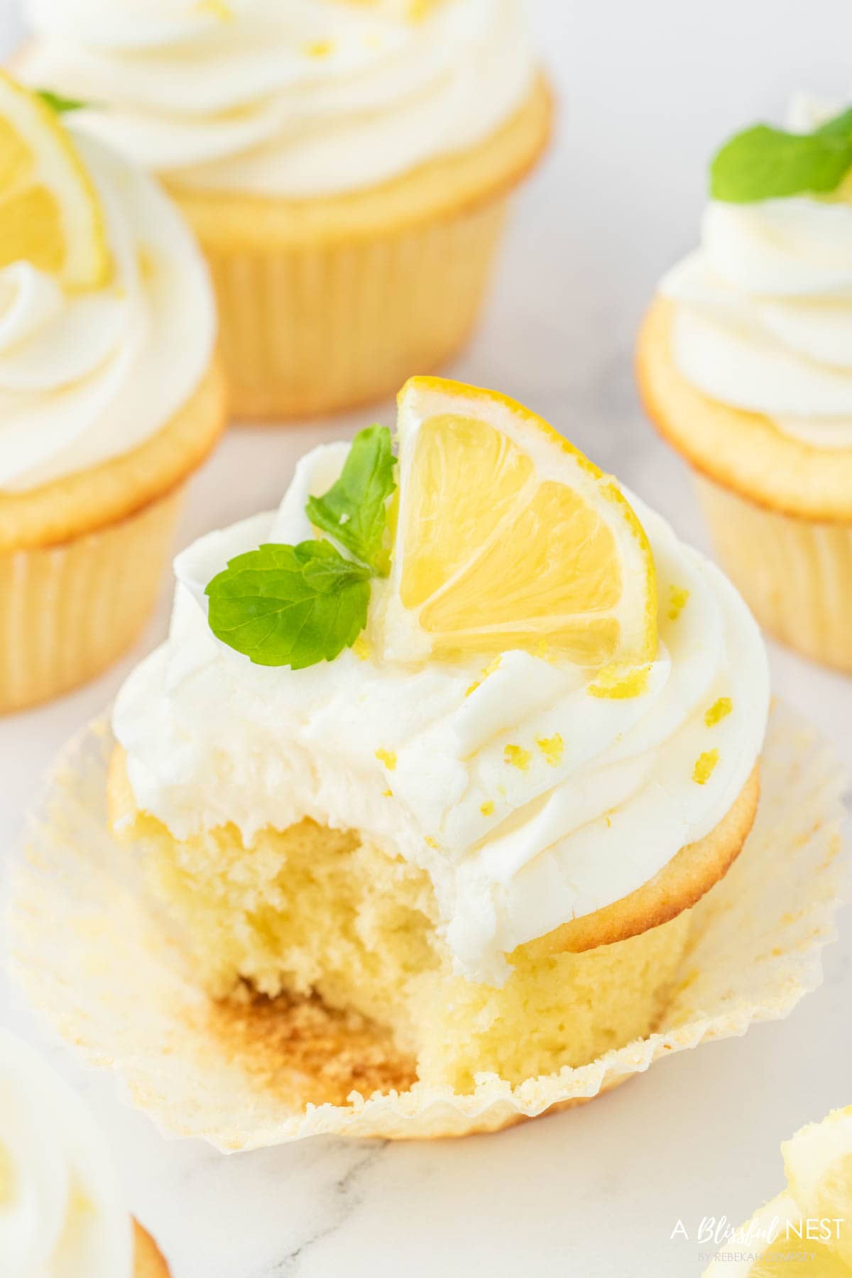 Lemon cupcake with a delicious bite taken.