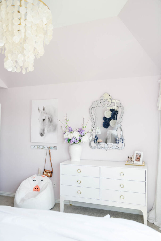 White dresser with venetian mirror above it and horse decor elements