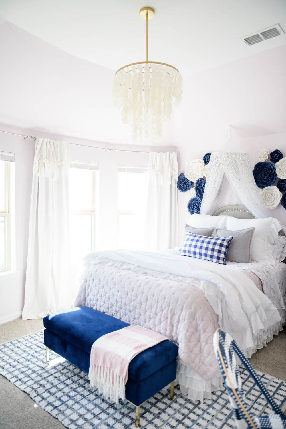 A lilac and navy tween girls bedroom with a capiz chandelier