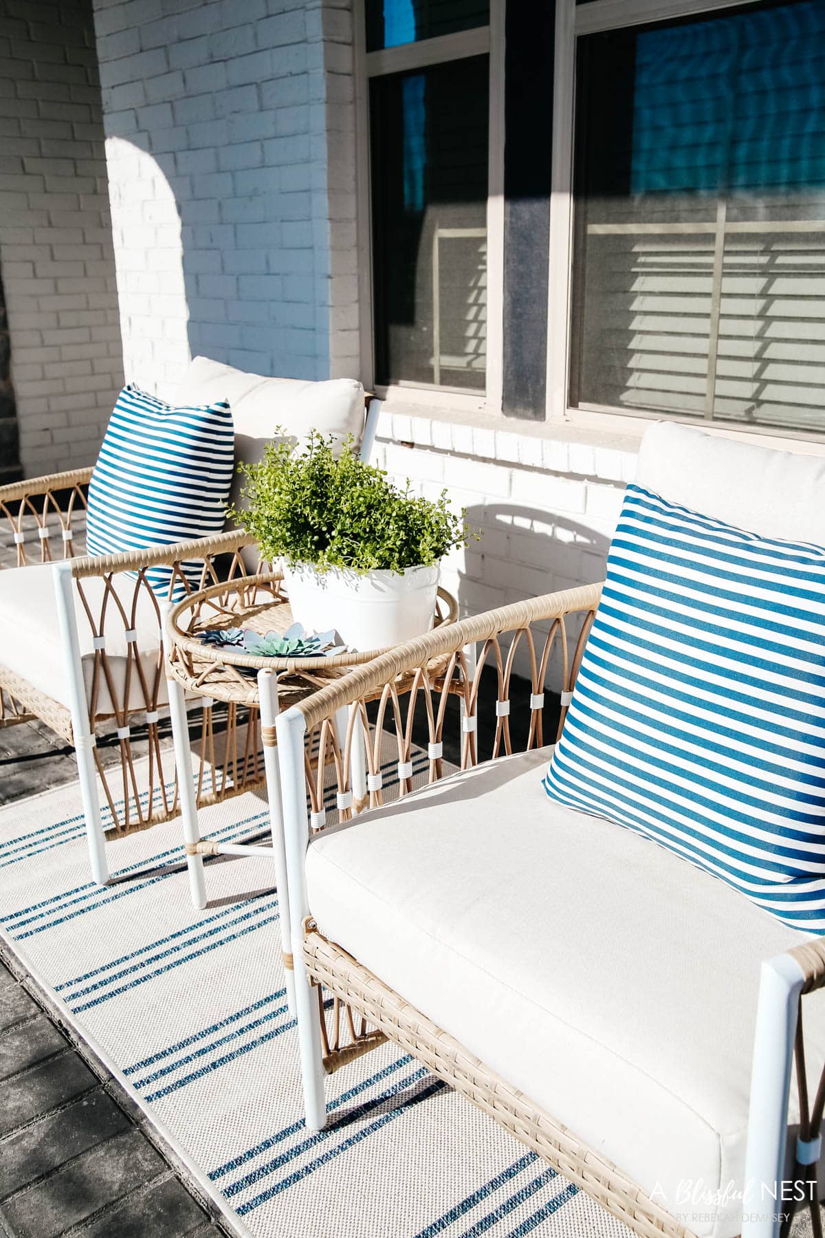 Navy and white striped outdoor pillows on side porch chairs