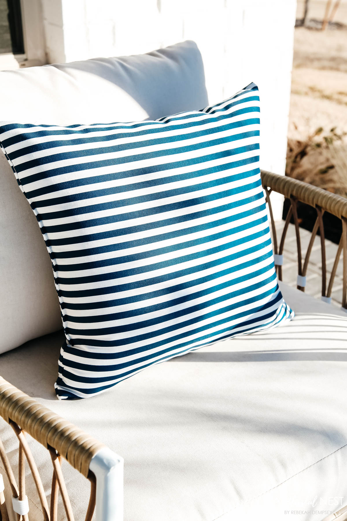 Navy and white striped outdoor pillows on side porch chairs