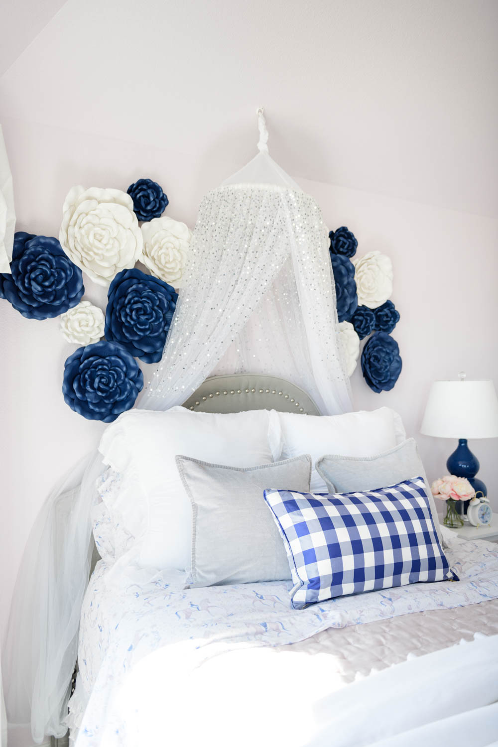 Grey upholstered bed with nailheads in a navy and purple bedroom